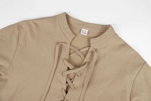 Macro shot of linen fabric texture and lace-up neck detail on beige vintage shirt