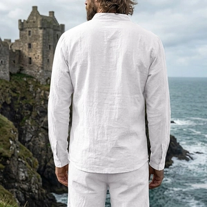 Rear view of white linen Henley shirt showing textured fabric against a coastal castle