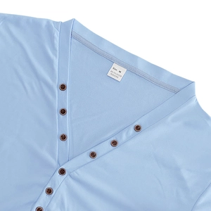 Close-up of light blue Henley V-neck with vintage brown buttons and size label details