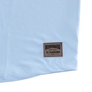 Detail of light blue knit Henley shirt showing mesh texture and vintage leather brand patch