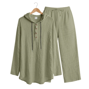 Detail of sage green linen set showing textured fabric with wood buttons and drawstring
