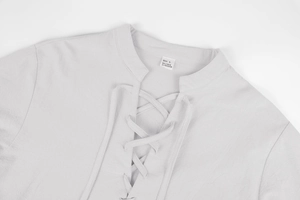 Close-up of linen shirt lace-up V-neck detail with size L label and natural fabric texture