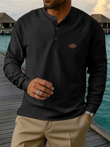 Men's black waffle knit Henley shirt with long raglan sleeves for a casual outdoor look