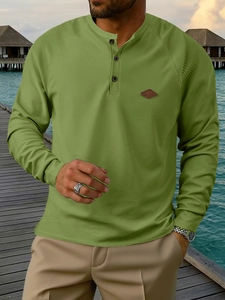 Detail of waffle knit fabric and three-button henley neck on green long-sleeve shirt