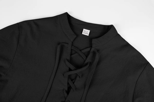 Macro detail of black linen fabric texture and lace-up V-neck collar with size label