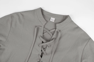 Detail of grey linen shirt neckline with vintage V-neck cross-lace design and fabric texture