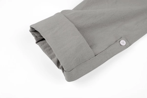 Detail view of the gray linen shirt cuff with white button and fine stitching texture