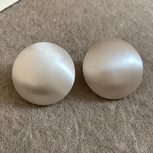 Boucles d'oreilles ovales en métal argenté brossé avec un design industriel chic