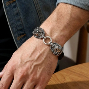 Detailed view of men's leather braided bracelet featuring vintage lion head carvings