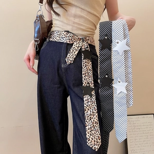 Detail view of Y2K style leopard and polka dot silk belts with star charm accents