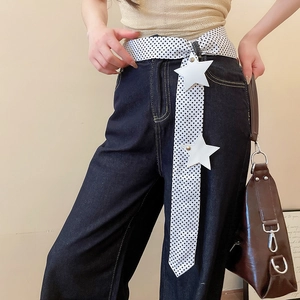 Close-up of Y2K style white polka dot belt with star patches on dark denim jeans