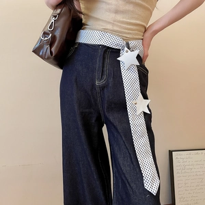 Detail view of Y2K polka dot belt featuring white leather star accents on dark denim