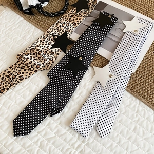 Close-up view of Y2K style polka dot and leopard print belts with leather star studs