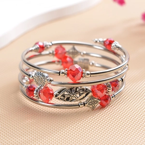 Close-up of multi-layer wrap bracelet with red faceted crystals and silver charms