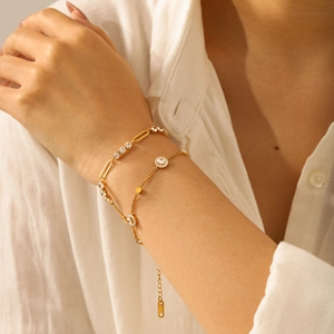 Close-up van goudkleurige titanium stalen armbandset met schitterende kristallen en bedels