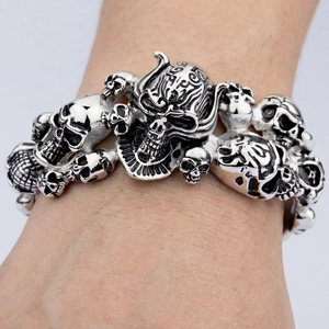 Detailed view of punk gothic multiple skull heads bracelet in vintage silver stainless steel