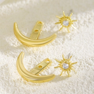 Detailed view of gold-tone sun and moon celestial stud earrings with clear crystals.