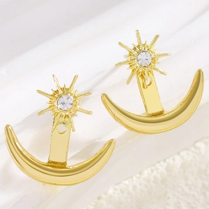Close-up detail of elegant gold star and moon earrings with sparkling clear rhinestones