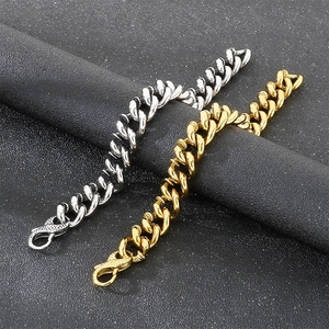 Détail de bracelets à maillons cubains en acier titane argent et or avec fermoir serpent texturé