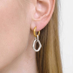 Detail of two-tone minimalist stainless steel hoop earrings in gold and silver finish