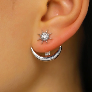 Detail view of silver star and moon ear jacket with a sparkling crystal sun stud