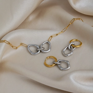 Elegant close-up of minimalist two-tone interlocking ring jewelry set on silk background
