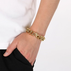 Vue rapprochée d'un bracelet hip-hop en acier titane doré avec fermoir serpent au poignet