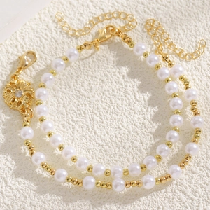 Primo piano dettagliato dell'elegante set collana e bracciale con perle bianche e oro