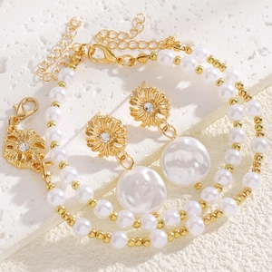 Dettaglio di un set di gioielli in perle barocche con eleganti orecchini a fiore