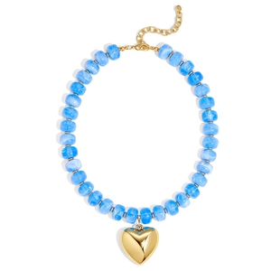 Detail of blue marbled resin beads and large gold heart pendant necklace for summer
