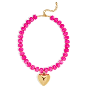 Close-up detail of the vibrant pink resin beads and gold heart pendant necklace.