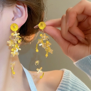 Detailed view of elegant yellow flower beaded drop earrings with delicate crystal accents.