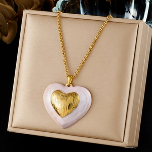 Close-up of French vintage pink enamel heart necklace with gold-textured center