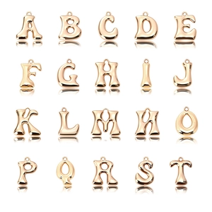 Makroansicht verschiedener goldener Alphabet-Anhänger mit hochglanzendem Metallic-Finish