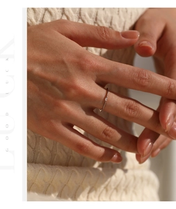 Close-up of minimalist S925 sterling silver ring with a tiny moissanite stone on finger