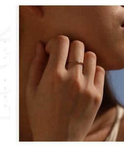 Detailed view of a minimalist S925 sterling silver ring with Moissanite on a model's finger