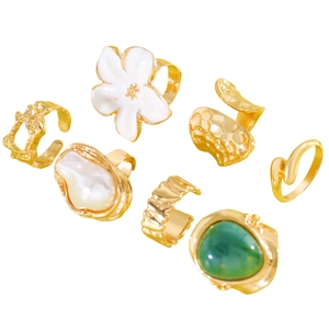 Detailed view of vintage gold alloy ring set featuring white flower and green stone