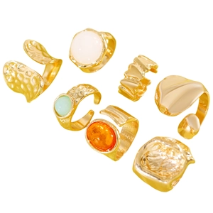 Close-up detail of vintage gold-plated alloy ring set with geometric and colorful resin designs