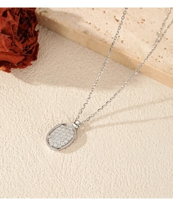 Detailopname van S925 zilveren ketting met ovale pavé gezette moissanite knophanger