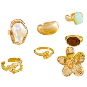 Detailed view of vintage gold-tone alloy ring set featuring flower and pearl designs
