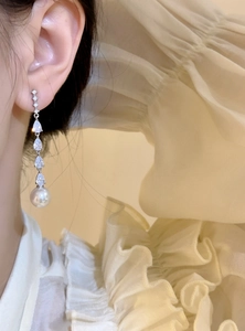 Elegant long drop earrings featuring pear-shaped cubic zirconia and a white pearl pendant