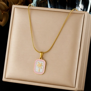 Gold-plated stainless steel necklace featuring a pink palm tree pendant on jewelry box.