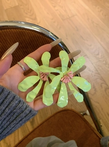 Macro view of oversized fluorescent green flower earrings for a summer vacation look