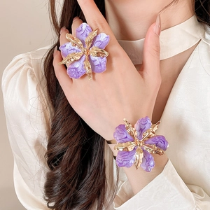 Primer plano de un anillo de flor violeta de gran tamaño y un conjunto de pulsera a juego
