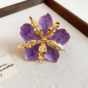 Detalle de un accesorio vintage flor de gota de aceite púrpura con acabado de metal dorado