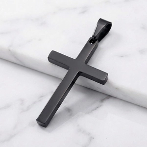 Close-up of minimalist black stainless steel cross pendant on marble background