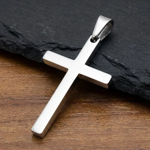 Detailed close-up of a minimalist polished cross pendant on a dark slate background.