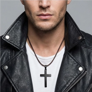 Close-up of minimalist black cross pendant necklace on male model with leather jacket