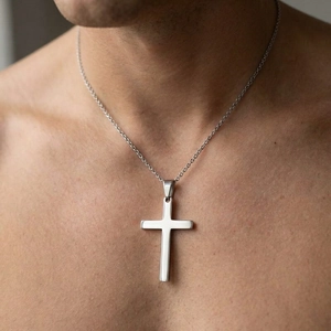 Detailed close-up view of a minimalist polished stainless steel cross pendant on a chain