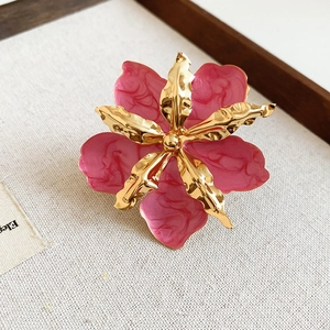 Primer plano detallado de un anillo de flor de esmalte rosa vintage con detalles dorados